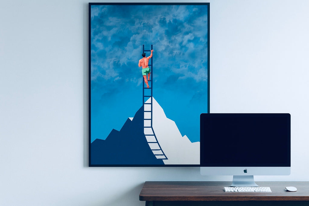Framed artwork of a person on a ladder reaching the sky above a mountain, displayed above a desk with a computer monitor.